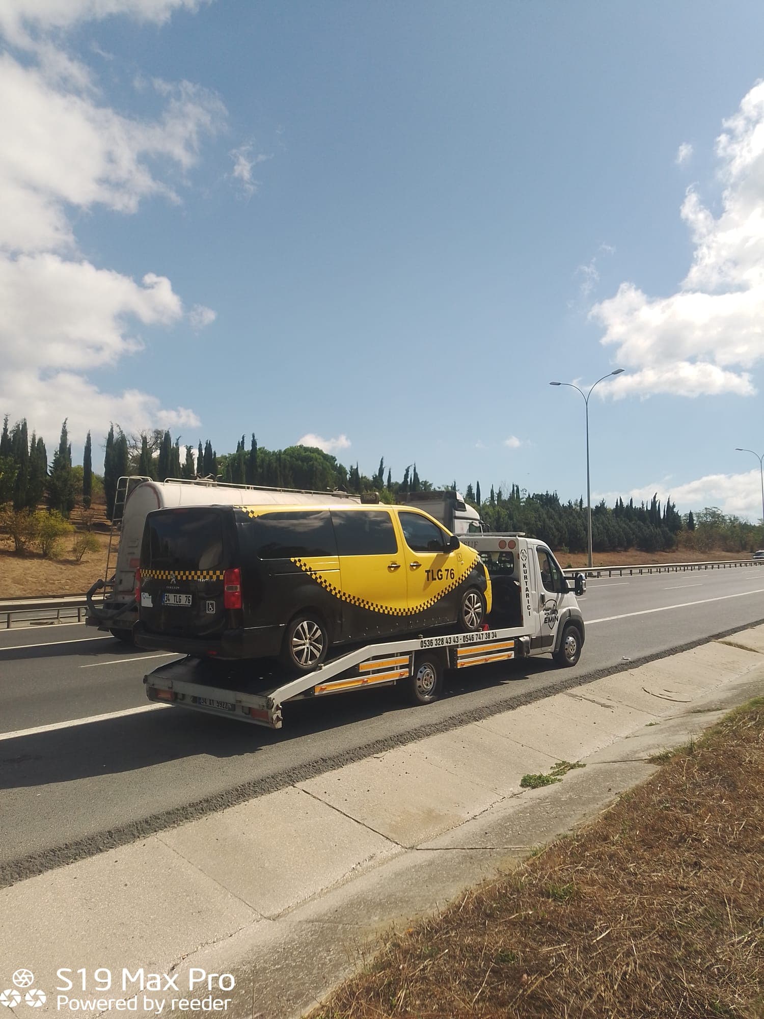 Otoyol emniyet şeridinde duran çekici, platformunda sarı siyah havalimanı servis minibüsü taşıyor